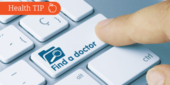A person's finger touches a computer key that reads "Find a doctor"