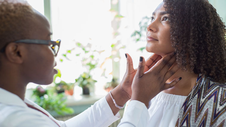 A family doctor performs an examination of a woman's lymph nodes