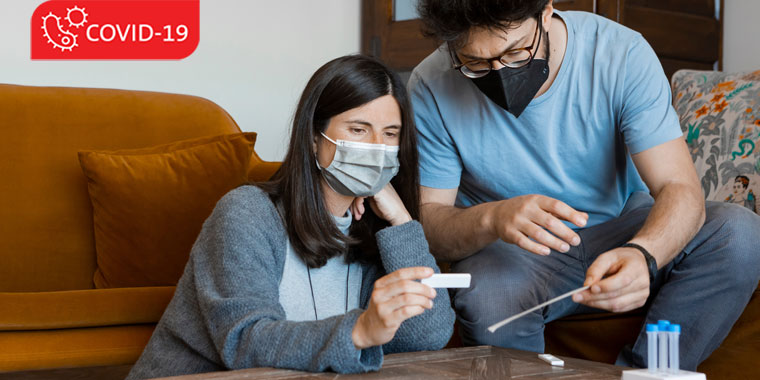 Two people check their at-home COVID tests