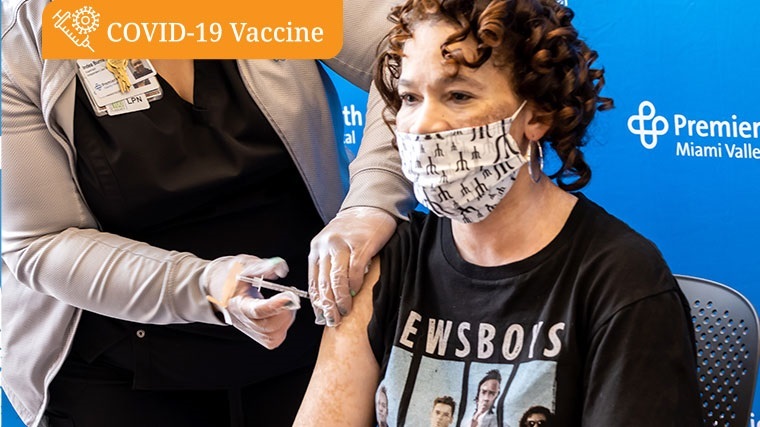 Woman receiving the COVID-19 vaccine wearing a Newsboys shirt