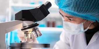 A scientist studies an mRNA cancer vaccine under a microscope