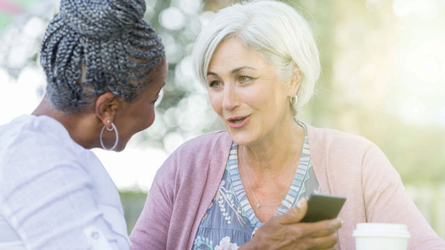 Two women ages 65 talking over coffee