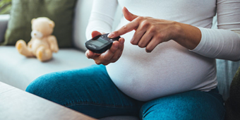 Pregnant woman with gestational diabetes checks her blood glucose level