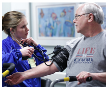 Jerry Christy has his blood pressure monitored by Austine Hagman during exercise at UVMC Cardiopulmonary Rehab department.