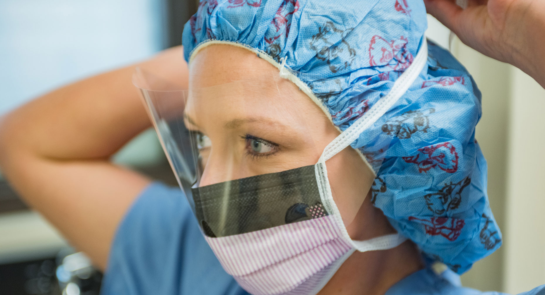 Nurse ties a mask to her face before a c-section